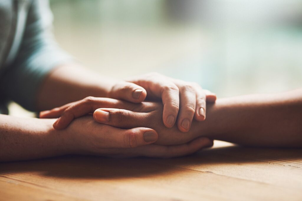 Holding hands and comforting.